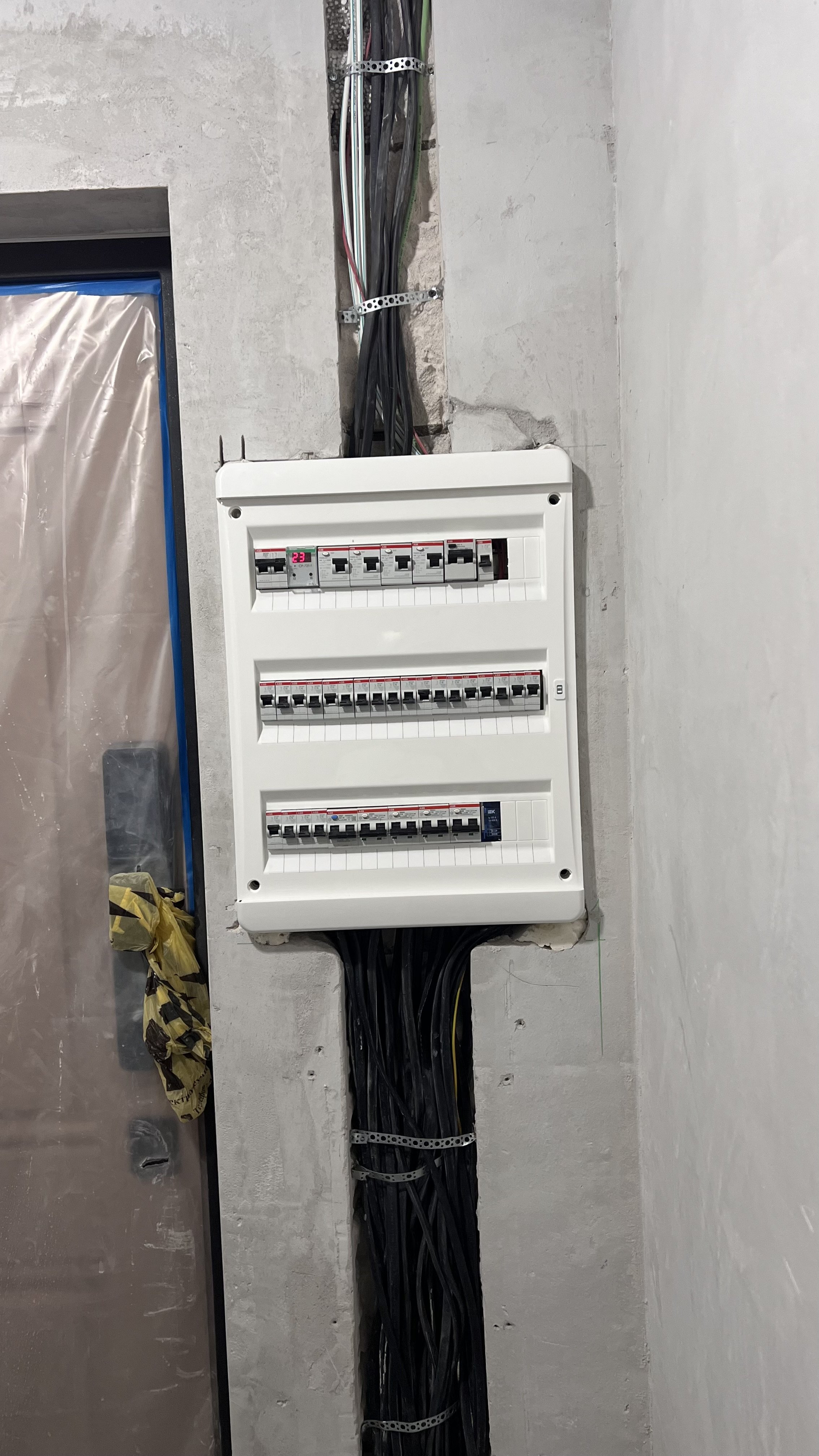 Электрощиток на стене. Провода, автоматические выключатели, монтаж электропроводки.